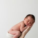 When should I take my newborn to a chiropractor - Austin mother holding peaceful baby during consultation