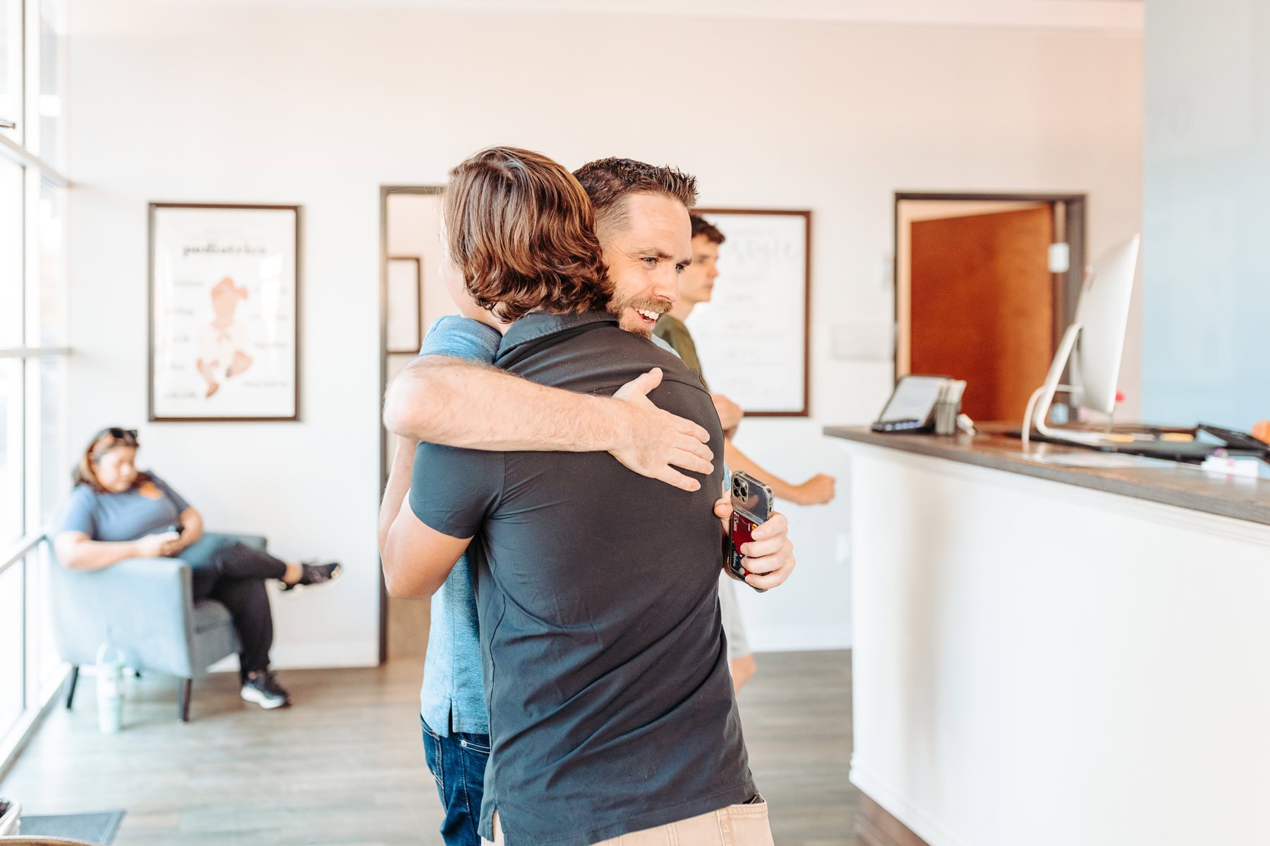 Two men hugging in welcome at River City Wellness